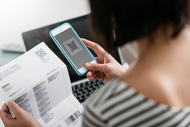 istock Woman paying bills with her smartphone 586374124