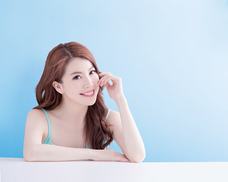 beauty woman smile and look you happily with isolated blue background, asian