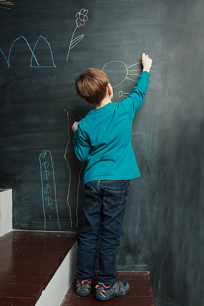 istock Little boy is drawing on a blackdoard 586376782