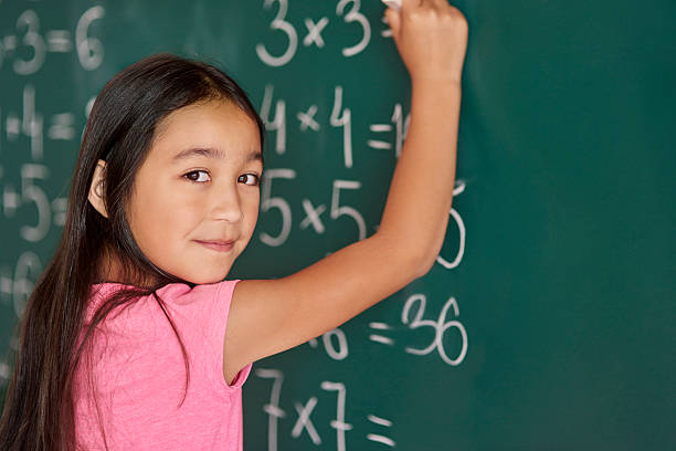 Girl making some exercises on the blackboard