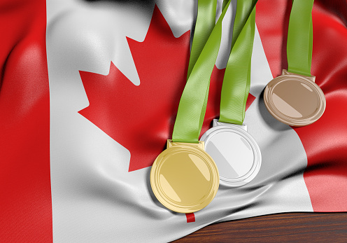 3D render of gold, silver, and bronze medals lying over the country flag of Canada for the 2016 games.