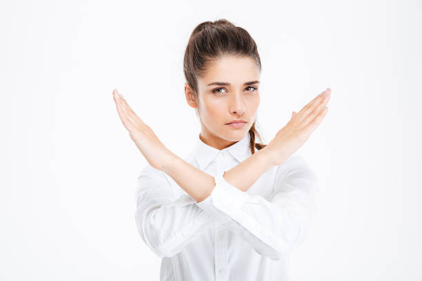 Beautiful young businesswoman with crossed hands showing stop gesture stock photo