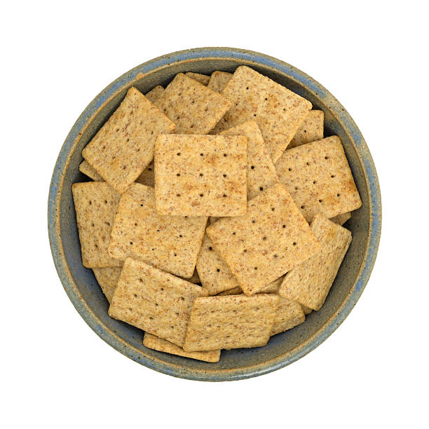 istock Bowl of organic whole wheat crackers on a white background 586384004