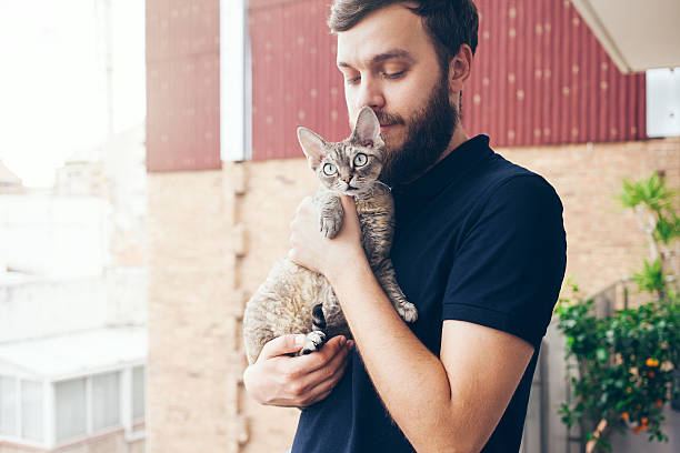istock Beautiful man holding and hugging cute curious devon rex cat 586384874
