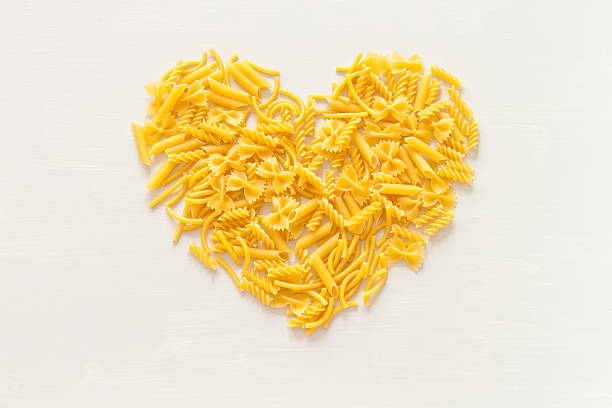 生パスタのトップビューハート - pasta directly above fusilli food ストックフォトと画像