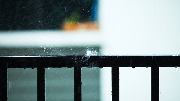 Rainy day in Bangkok - water drops falling down on railing of balcony