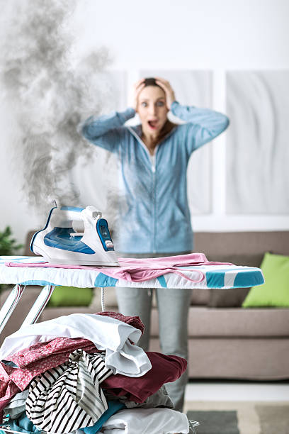 неосторожная домохозяйка дома - iron women ironing board stereotypical housewife стоковые фото и изображения
