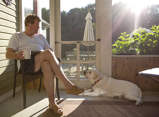 Man using phone with his French Bulldog sleeping on his lap