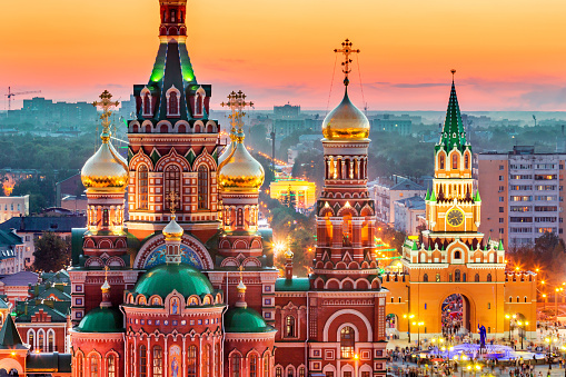Nice view of the town at sunset. Orthodox church surrounded by beautiful red brick buildings on the city's embankment. Volga region of Russia, the city of Yoshkar-Ola