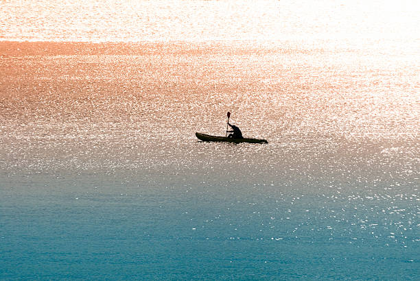 A shot of a canoeist rowing in the sea early in the morning