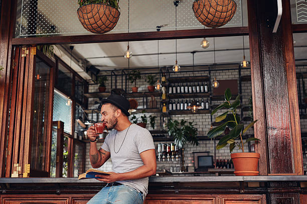 istock Happy young man at cafe with a book 586392806