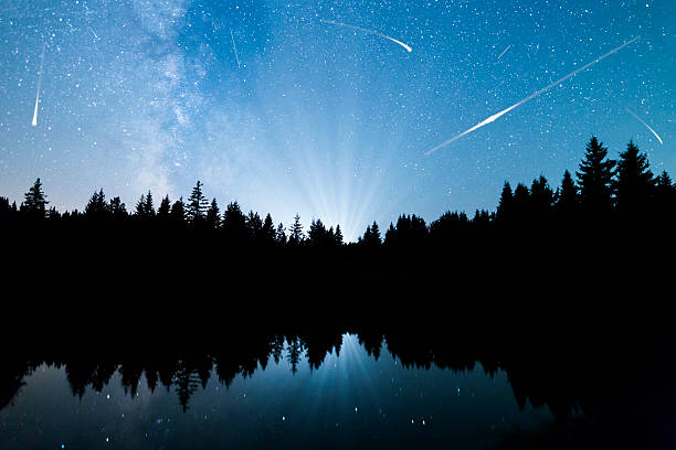 istock Falling stars Lake pine trees silhouette Milky Way 586392926