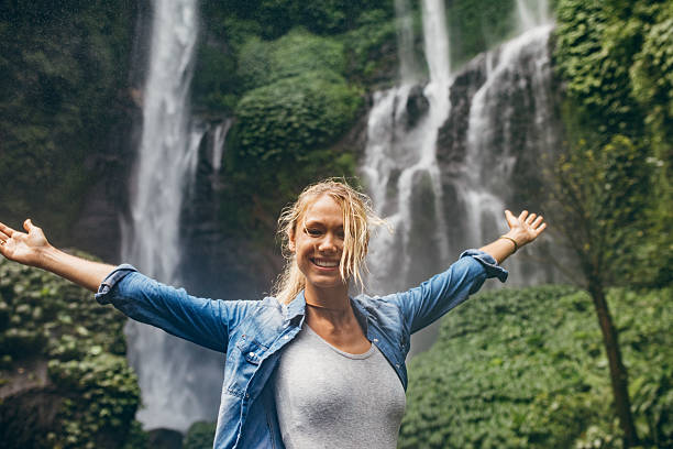 istock Tourist with tropical waterfall in background 586393848