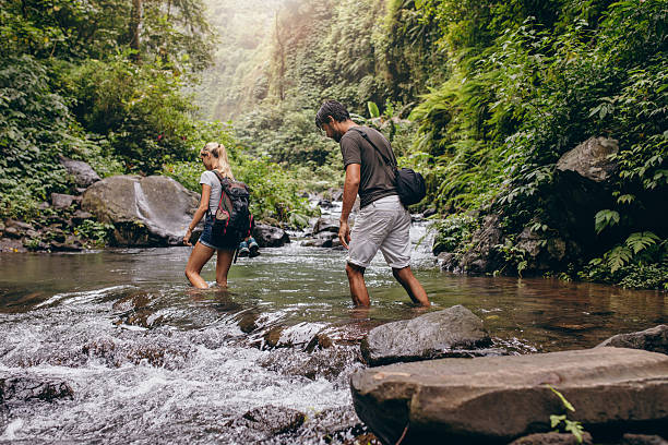 istock Couple walking across the stream. 586393910