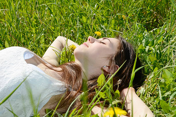 istock woman lying on flower meadow 586394274