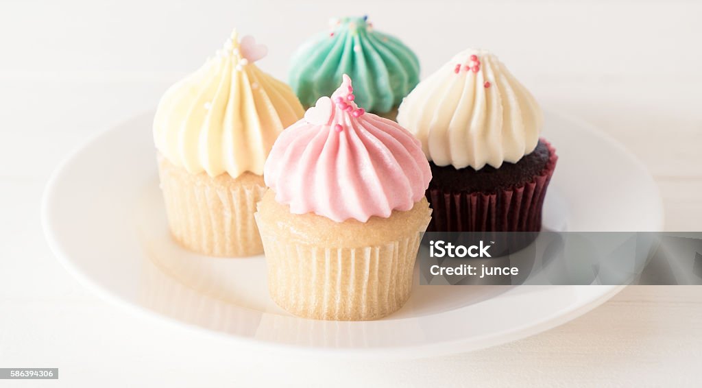 Cup Cakes on white plates in pastel color Cup Cakes on white plates in pastel color. Selective focus on front cup cake muffins on white background. Cupcake Stock Photo