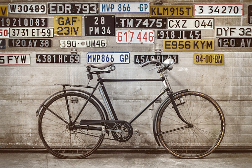 Ancient bicycle in front of an old factory door with number plates