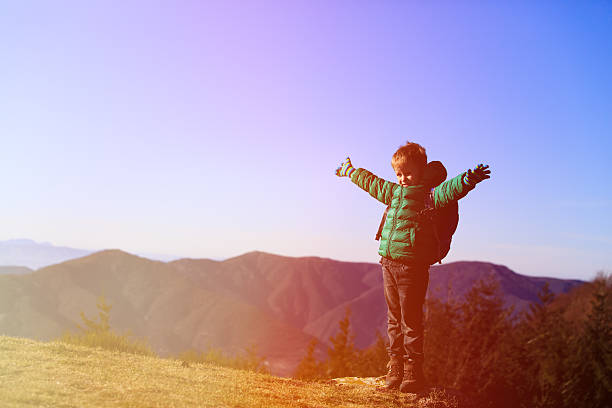 istock little boy with backpack travel in mountains 586693590