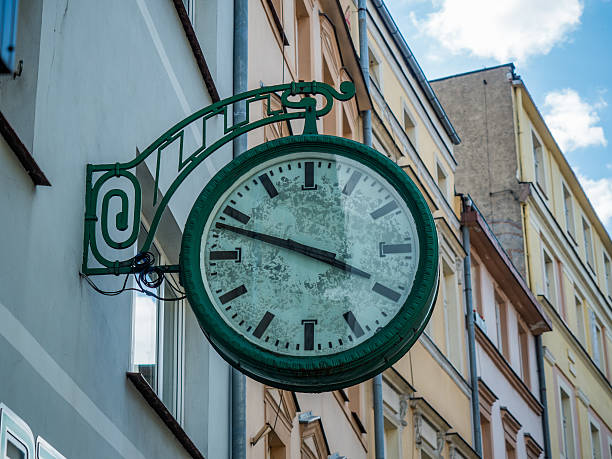 istock old vintage clock hanging on a wall in town square 586693802