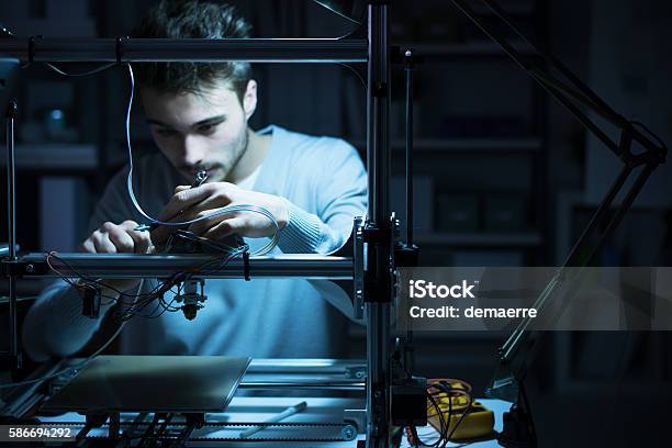 Young Engineer Working On A 3d Printer Stock Photo - Download Image Now - 3D Printing, Engineer, Innovation