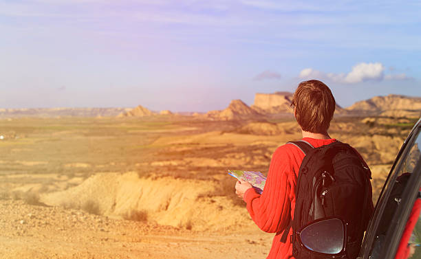 istock young man looking at map while travel by car in 586694354