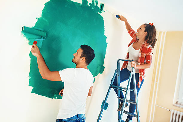 istock Couple painting walls. 586694944