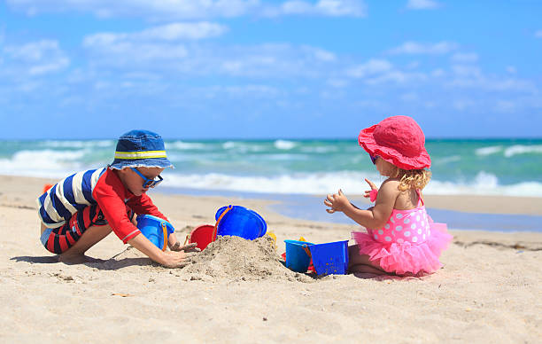 istock kids play with sand on summer beach 586695220