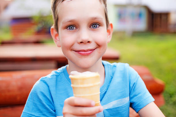 freudiger junge mit eis in der hand - child chocolate ice cream human mouth stock-fotos und bilder