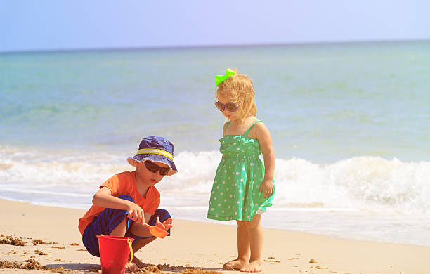 istock kids play with sand on summer beach 586695524