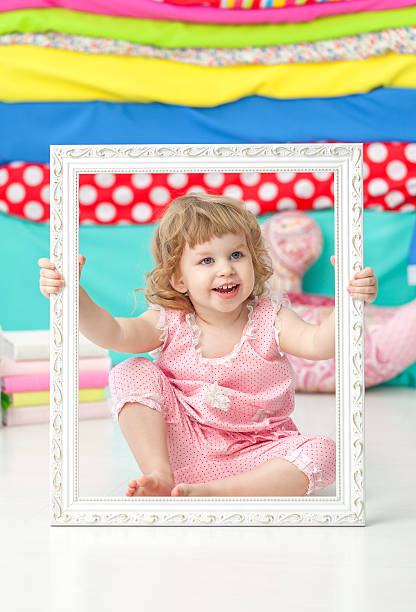 istock Little cute girl in pink suit smiling over white frame. 586696084