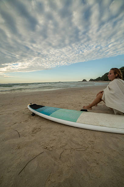 istock Surfer girl resting on beach 586696226