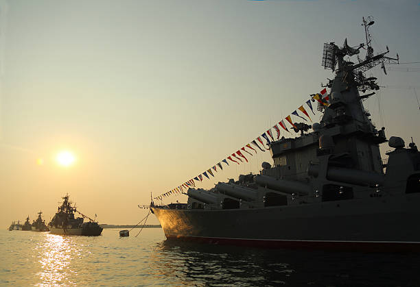 istock silhouette of military ships on sunset 586696532