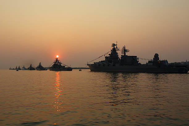 istock silhouette of military ships on sunset 586697878