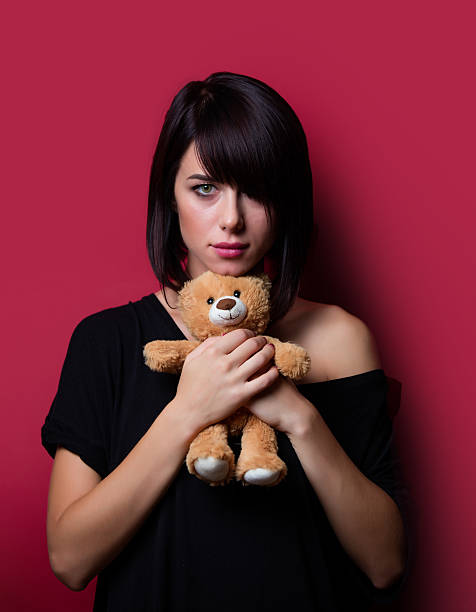 istock young woman with teddy bear 586698522