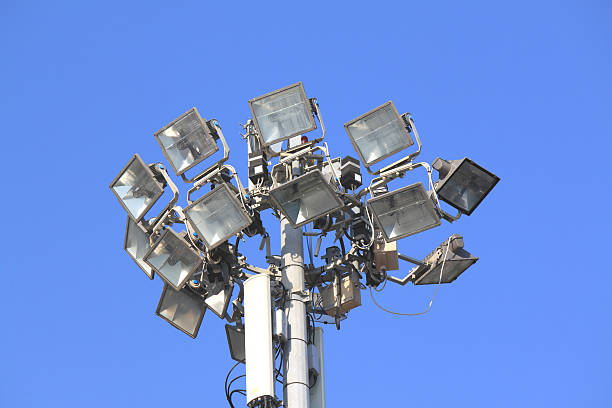 istock Many bright spotlights on a pole against the blue sky 586699182