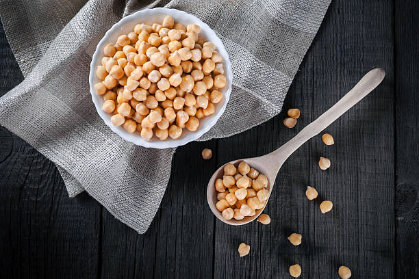 Chickpeas in bowl, top view Steamed gold chickpeas in bowl on tablecloth with wooden spoon, tasty vegan food, top view middle eastern food photos stock pictures, royalty-free photos & images