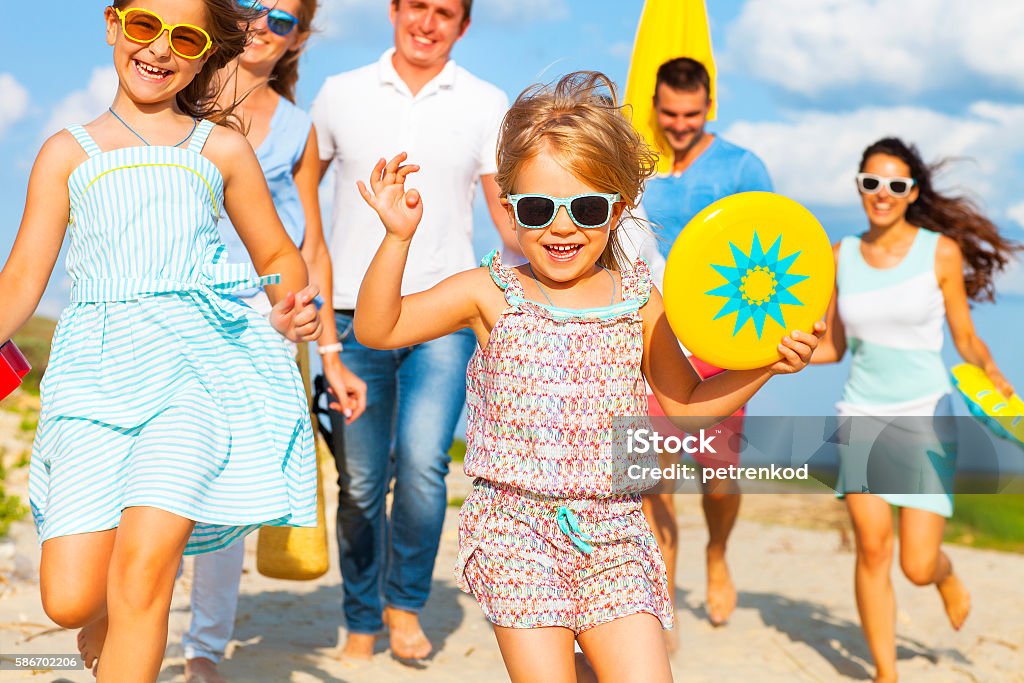 Multiracial group of friends walking at the beach Multiracial group of friends with children walking at the beach Family Stock Photo