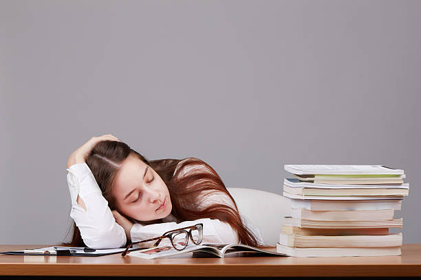 молодой студент спит на столе - schoolgirl boredom frustration adult student стоковые фото и изображения