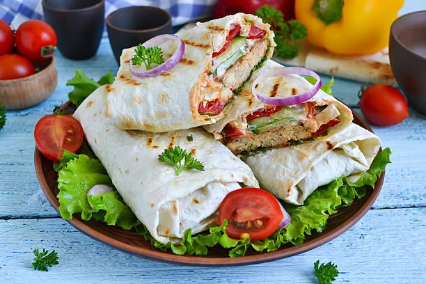 istock shawarma Lavash with chicken, tomatoes, lettuce and peppers on a 586702408