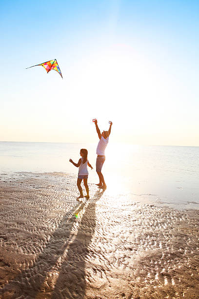 istock Happy young father with daughter and flying kite on beach 586702984