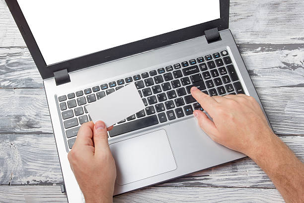 istock Hands holding business credit card typing numbers, laptop computer pc 586704116
