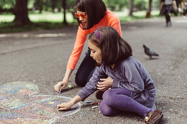 bambini disegno con gesso sull'asfalto - little girls sidewalk child chalk foto e immagini stock