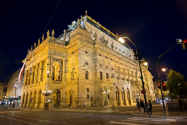 Detail of the Czech National Theatre in Prague illuminated at night. Blurred motion effect on car lights due to long exposition time.