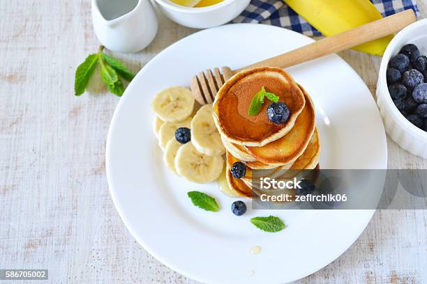 Small Pancakes Stacked With Blueberries Banana And Honey Stock Photo - Download Image Now