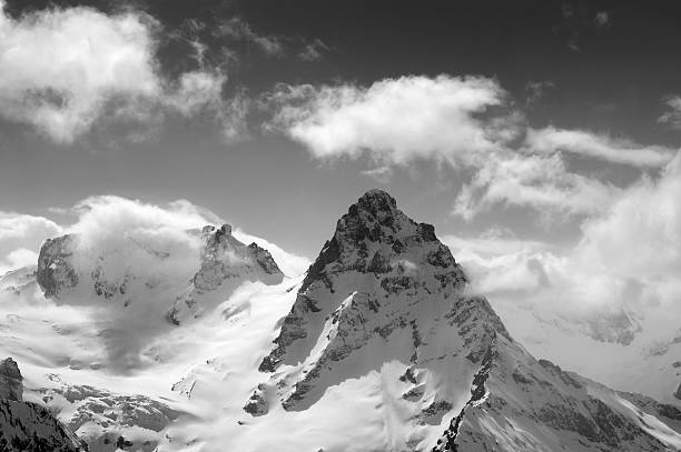 istock Black and white winter mountains in clouds 586706192