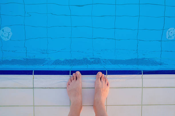istock man standing on the pool edge  befor go to swiming 586707318