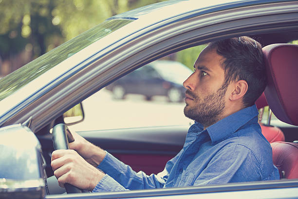 scared man driver in car. Inexperienced anxious motorist