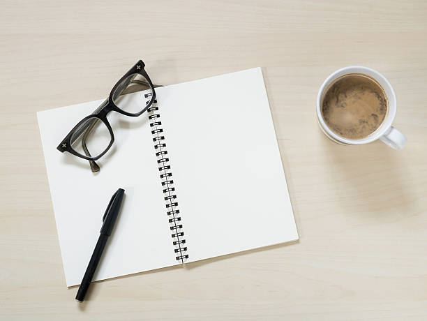 istock Notebook with vintage eyeglasses, pen and cup of hot coffee 586709162