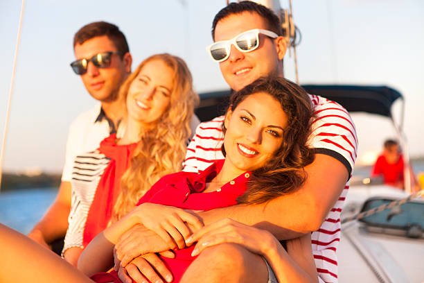 istock Smiling friends on yacht deck and greeting 586709590