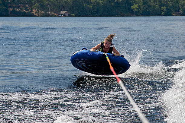 teenager tubing hinter einem boot auf lake of bays - motorbootfahren stock-fotos und bilder